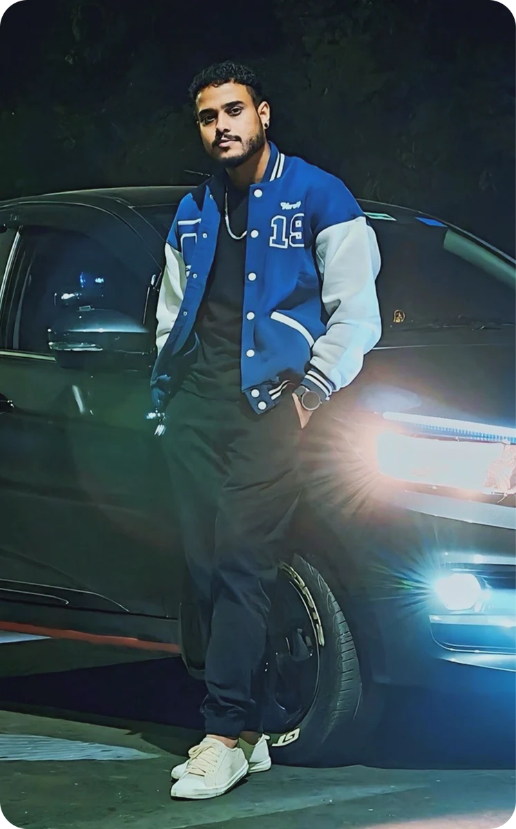 Shouvik standing beside his car at night